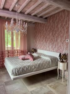 a bedroom with a bed and a chandelier at L’ Aia del Principe in Montepulciano