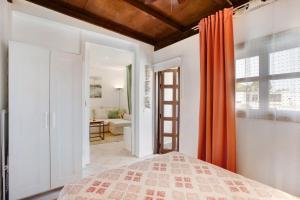 a bedroom with a bed with an orange curtain at El Drago in Costa Del Silencio +17 photos
