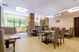 a restaurant with tables and chairs and a counter at Hotel Podium in Wisła