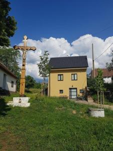 a church with a cross in front of a house at Vinohradnícky domček in Vrádište