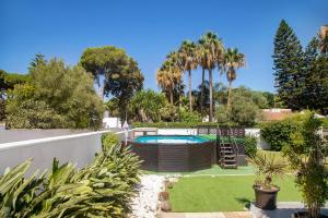 einen Garten mit einem Pool und Palmen in der Unterkunft Estudio Limón y Sal in Chiclana de la Frontera