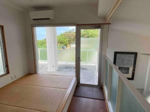 Habitación con escalera y puerta corredera de cristal. en Vacation Rental Kally Naha Okinawa en Naha