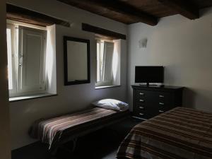 a bedroom with a bed and a dresser and two windows at Affitti brevi FESAGI in Laurino