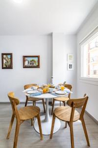 jadalnia z białym stołem i krzesłami w obiekcie Livemálaga Victoria Suites w Maladze