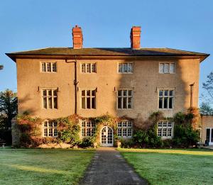 a large brick building with a grass yard at Woodborough Hall in Woodborough
