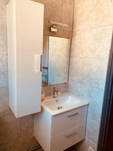 a bathroom with a white sink and a mirror at L'Eldorado Ruthénois - Garage & Terrasse in Rodez