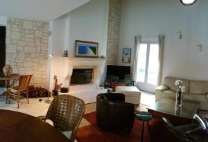 Una sala de estar con chimenea y una mesa y sillas. en Villa avec Piscine chauffée et parc arboré située à 100 m de la Plage et Forêt sans vis à vis, en Saint-Trojan-les-Bains