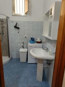 La salle de bains est pourvue d'un lavabo blanc et de toilettes. dans l'établissement Casa Vacanze A Due Passi dal Mare, à Portopalo di Capo Passero