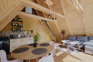 eine Küche und ein Wohnzimmer mit einem Tisch und einem Sofa in der Unterkunft Waterfall A Frame, Maramures in Baia Mare