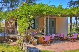 a patio with a table and chairs under a pergola at Vintage country house in Halkidiki in Nea Fokea