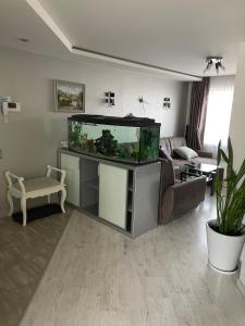 een woonkamer met een aquarium op een standaard bij Emporium Apartments in Rēzekne