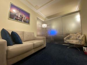 uma sala de estar com um sofá e uma cadeira em Itatiaia Hotel Passo Fundo em Passo Fundo