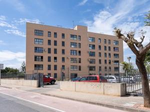 a large building with cars parked in a parking lot at Beautiful apartment in Canet Playa. WIFI! in Canet de Berenguer