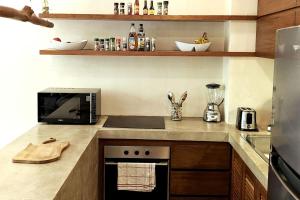 a kitchen with a counter with a microwave and a stove at Bai-Ha Luxury 103 in Tulum