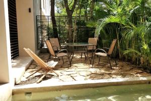 a patio with a table and chairs next to a pool at Bai-Ha Luxury 103 in Tulum