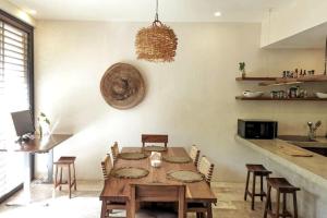a dining room with a wooden table and chairs at Bai-Ha Luxury 103 in Tulum