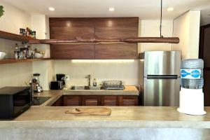 a kitchen with a stainless steel refrigerator and a counter at Bai-Ha Luxury 103 in Tulum +11 photos