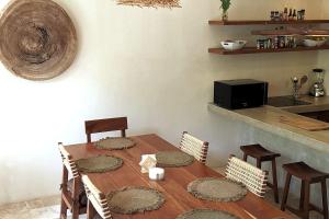 a dining room with a wooden table and chairs at Bai-Ha Luxury 103 in Tulum