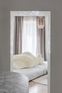 a white bedroom with a bed in a mirror at Luxe Rome apartment in Rome