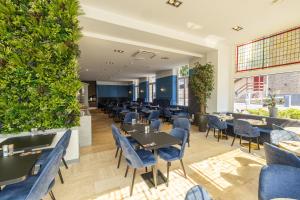 een restaurant met tafels, stoelen en planten bij Atlas Hotel in Valkenburg