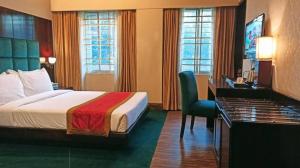 een hotelkamer met een bed en een bureau bij West Park Inn in Dhaka