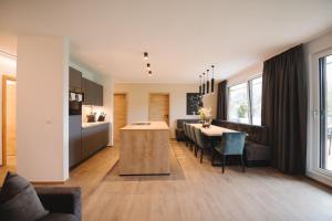 uma cozinha e sala de estar com uma mesa e uma sala de jantar em Das Lenz by Inncomer em Oberau
