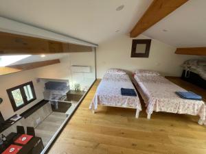 two beds in a room with wooden floors at 20 metri dal mare in Imperia