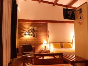 a bedroom with a bed and a brick wall at Hôtel Restaurant LE COMBAVA in Antananarivo