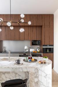 a kitchen with a marble counter top and wooden cabinets at Luxe Rome apartment in Rome