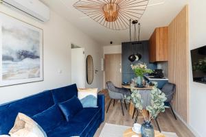 een woonkamer met een blauwe bank en een tafel bij Baltic Residence - LoftAffair in Gdańsk +221 foto's