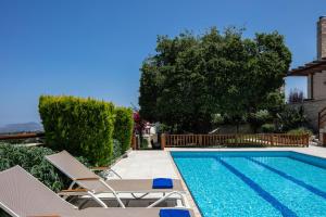 a swimming pool with two lawn chairs and a swimming pool at Villa Eleftherna in Elefterna