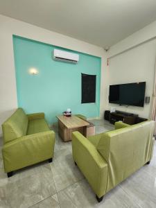 a living room with two chairs and a flat screen tv at Lang duo duo Homestay in Huxi