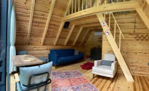 ein Wohnzimmer mit einer Treppe in einem Blockhaus in der Unterkunft Lelvani Suite Bungalow in Rize
