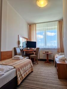 Cette chambre comprend deux lits et un bureau. dans l'établissement Hotel ARA - Dancing Club Restauracja ARA, à Jastrzębia Góra