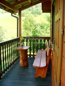 een houten bank en een tafel op een veranda bij Agroturystyka Pod Bocianami Terka in Polańczyk