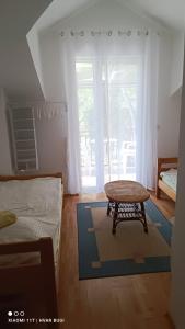 a bedroom with a bed and a table on a rug at Adrienn Apartments in Stari Grad