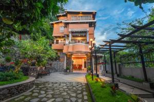 Edificio de aominio con una pasarela delante de él en Summit Bougainvillea Tea Resort, en Kurseong