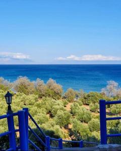 a view of the ocean from a blue fence at De La Plage Hotel Koroni in Koroni