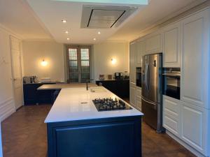 a large kitchen with a blue island in the middle at Manoir remarquable avec son parc in Chaumes-en-Brie