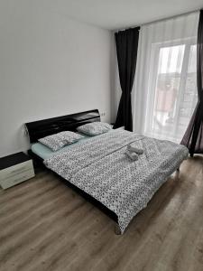 a bedroom with a bed and a large window at New Apartament Baia Mare 35 in Baia Mare
