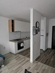 a kitchen with white cabinets and a stove top oven at New Apartament Baia Mare 35 in Baia Mare