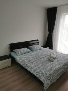 a bedroom with a bed with a pair of shoes on it at New Apartament Baia Mare 35 in Baia Mare