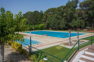 a large swimming pool with people in it at Càmping Vila Village in Sant Feliu de Buixalleu