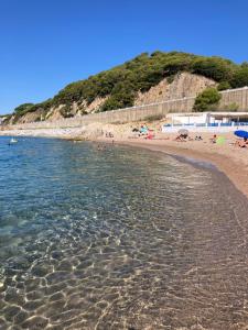 una playa con gente tirada en la arena y el agua en Casa con vista y jardín, a 20' de la playa en Sant Cebrià de Vallalta