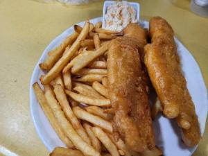 a plate of food with french fries on a table at Sherbrooke Village Inn in Sherbrooke +23 photos