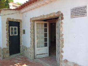 an entrance to a white building with an open door at Retiro d'Azenha in Almoster