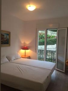 1 dormitorio con 1 cama con lámpara y ventana en Nice 4 Person apartment residence La Sella Golf Resort Marriott Denia, en Pedreguer