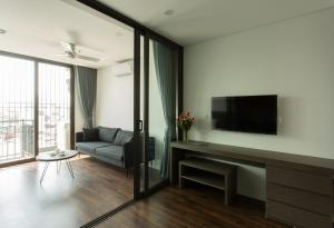 ein Wohnzimmer mit einem Sofa und einem Flachbild-TV in der Unterkunft 402 Thecarnationapartments Hanoi in Hanoi