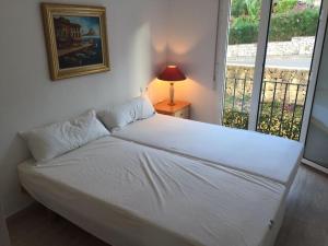 a white bed in a room with a window at Nice 4 Person apartment residence La Sella Golf Resort Marriott Denia in Pedreguer