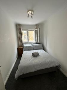 a bedroom with a white bed with a window at Narrow Street in London